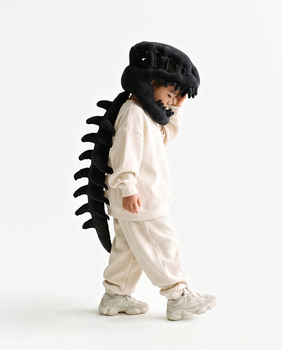 The Dinosaur Skeleton in Black — plush dinosaur skeleton costume with skull hood and spine, side view
