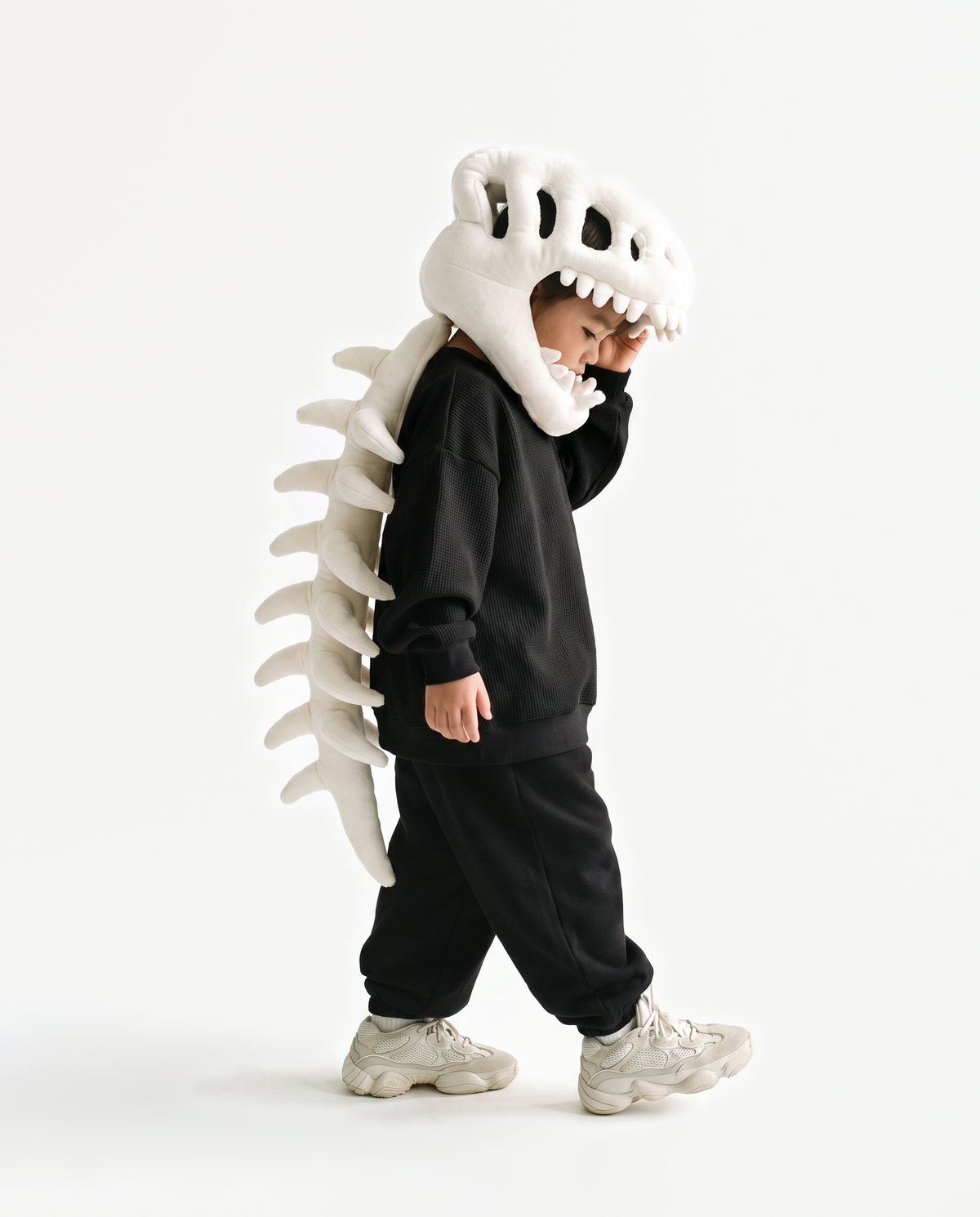 The Dinosaur Skeleton in Bone — plush dinosaur skeleton costume with skull hood and spine, side view