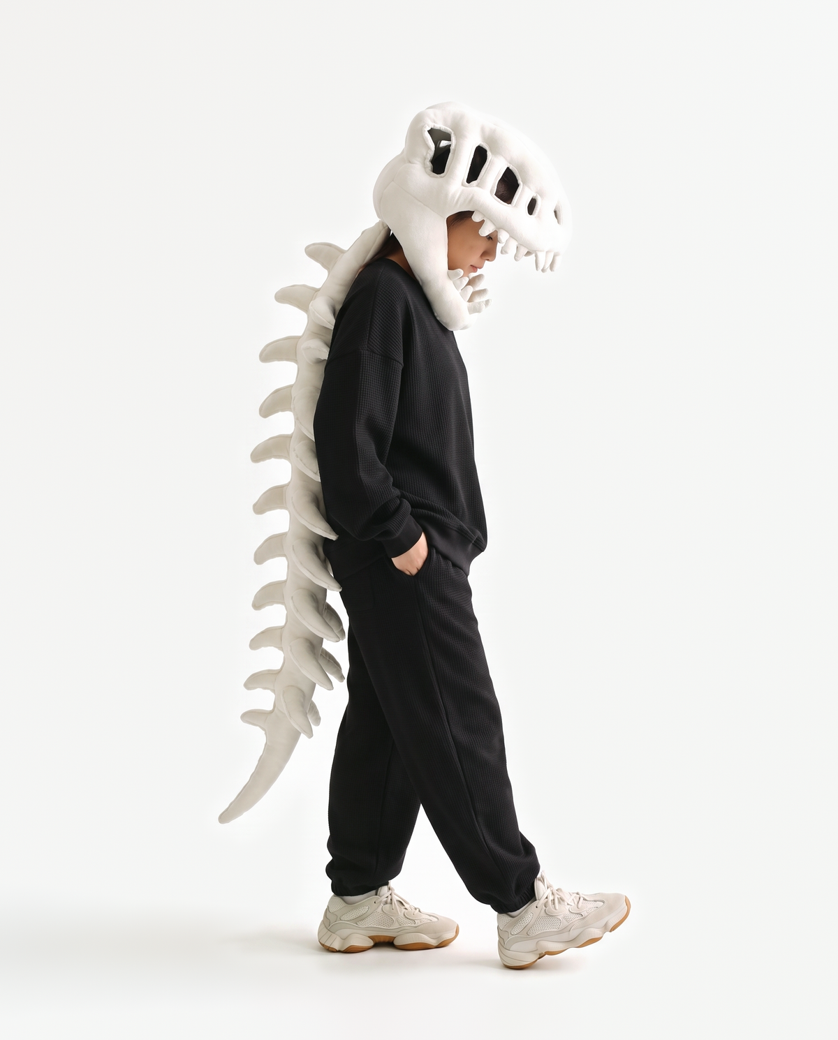 The Dinosaur Skeleton in Bone — plush dinosaur skeleton costume with skull hood and spine, side view