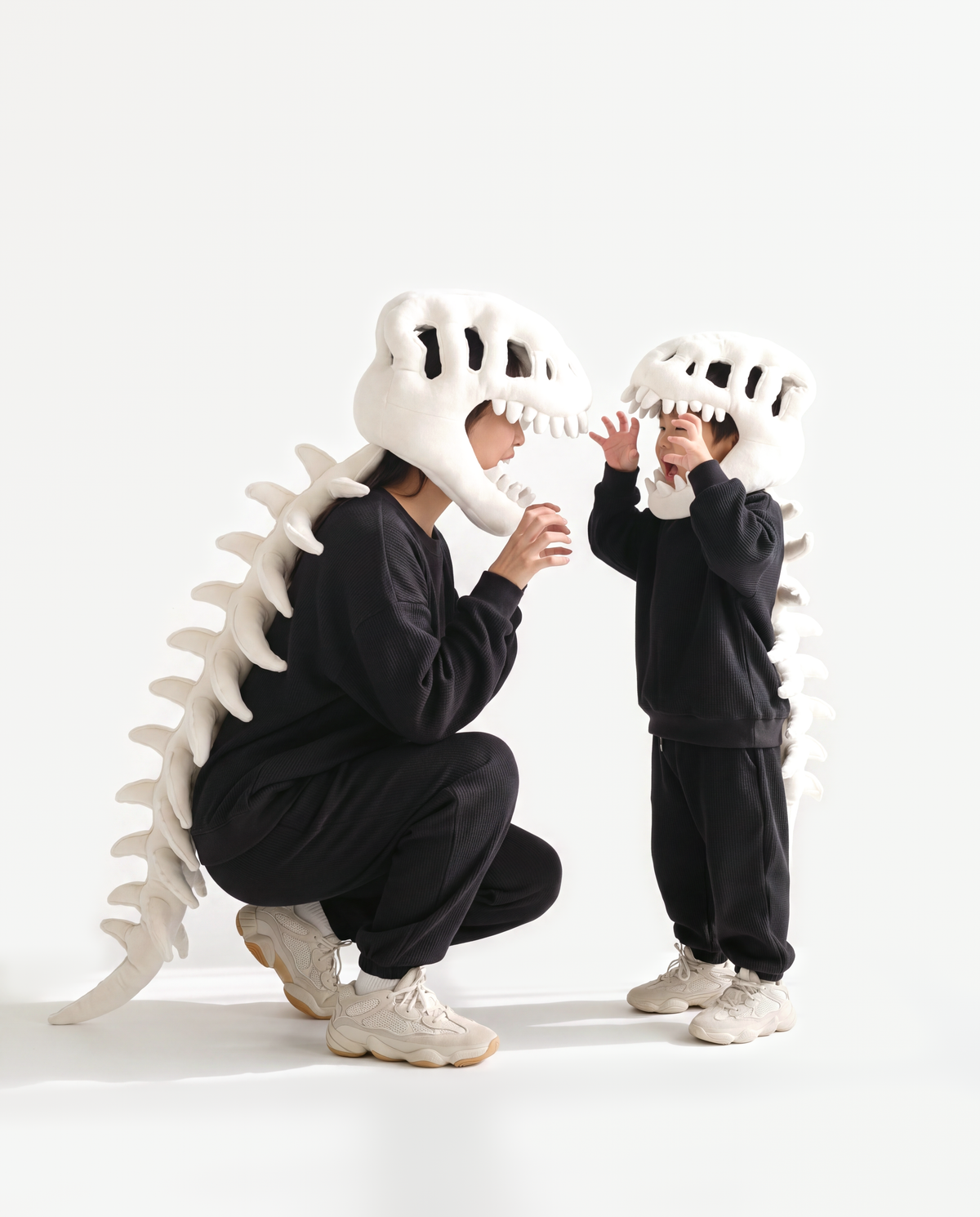 Adult and kids plush Dinosaur Skeleton costumes in Bone, crouching together