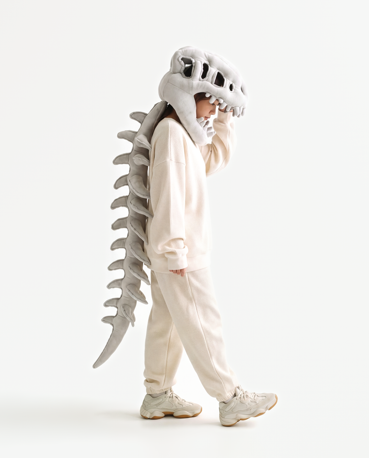 The Dinosaur Skeleton in Grey — plush dinosaur skeleton costume with skull hood and spine, side view