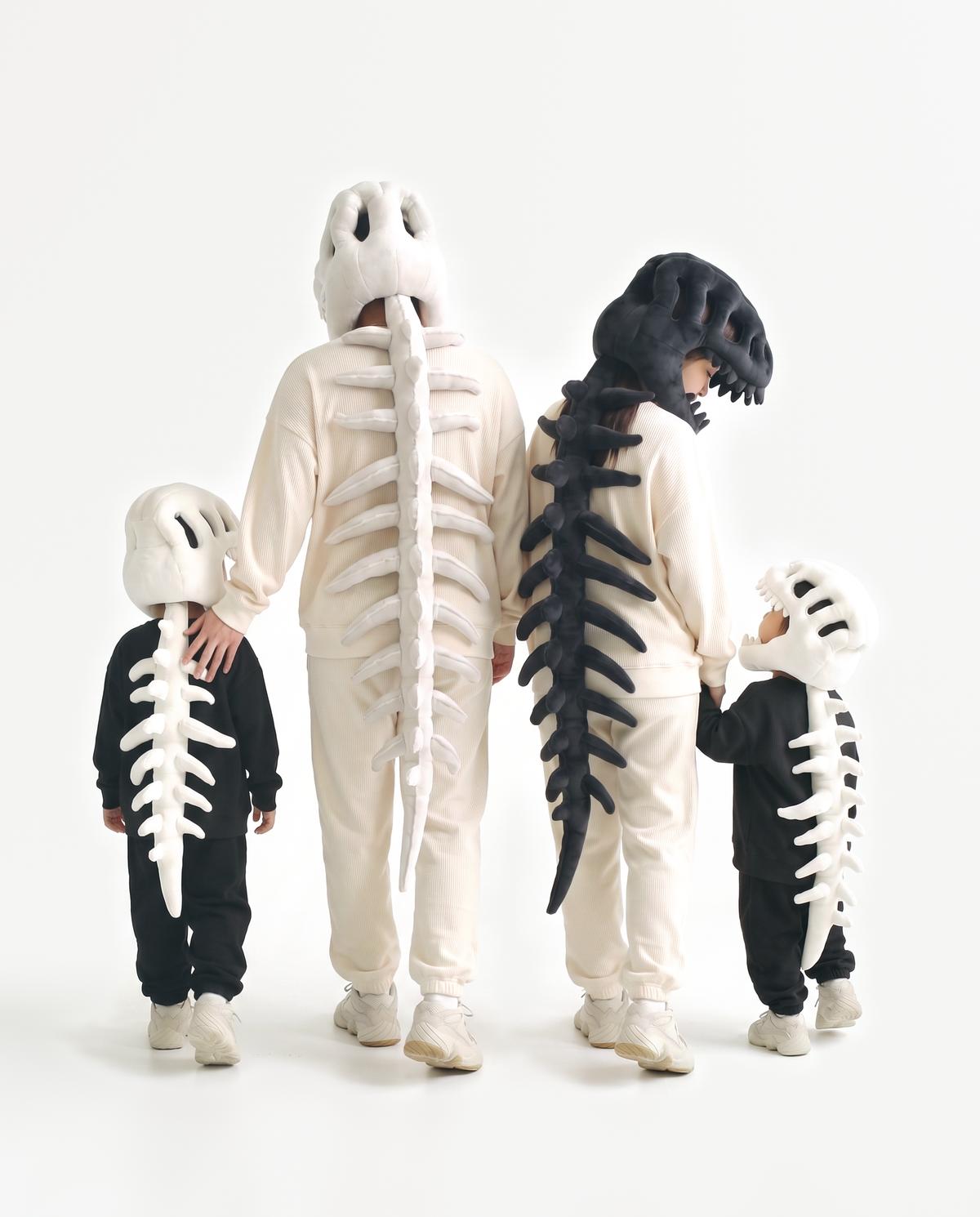 Four plush Dinosaur Skeleton costumes in Bone and Black — group Halloween costume