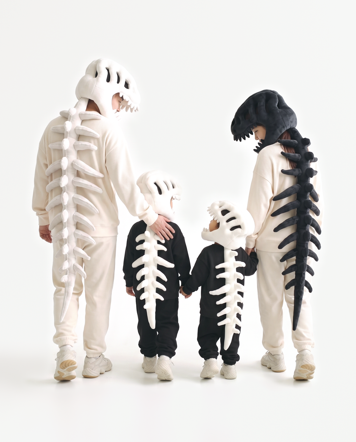 Four plush Dinosaur Skeleton costumes in Bone and Black — group Halloween costume