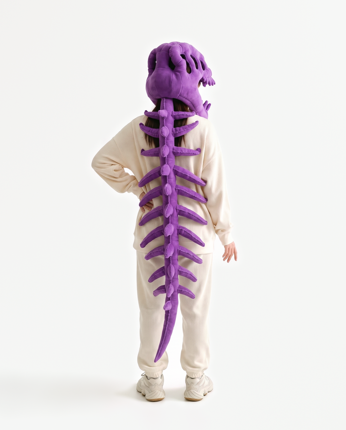 The Dinosaur Skeleton in Purple — plush dinosaur skeleton costume seen from behind, spine down the back